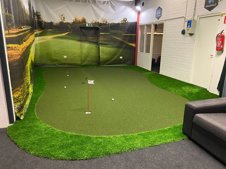 Puttiviheriö sisätiloissa golfkenttämaalauksen edessä.